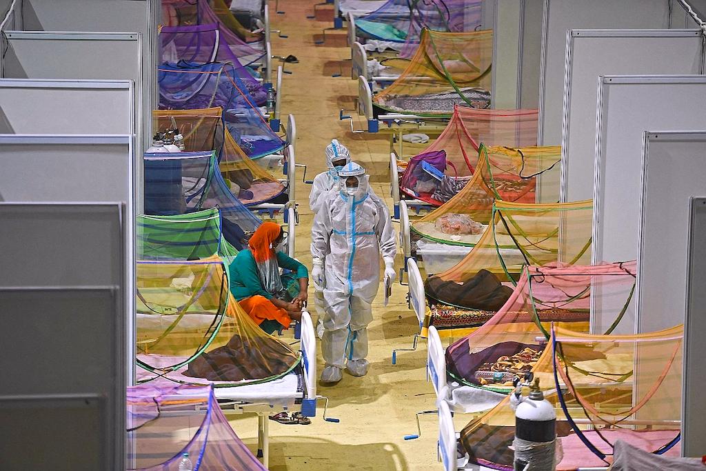 TOPSHOT - Health workers wearing personal protective equipment (PPE) suits attend Covid-19 coronavir